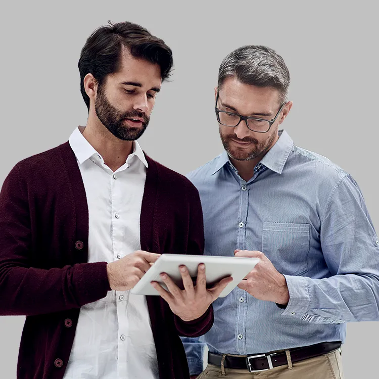 Deux syndics de copropriété analysant des informations sur une tablette pour la gestion d’immeuble et le contrôle d’accès.